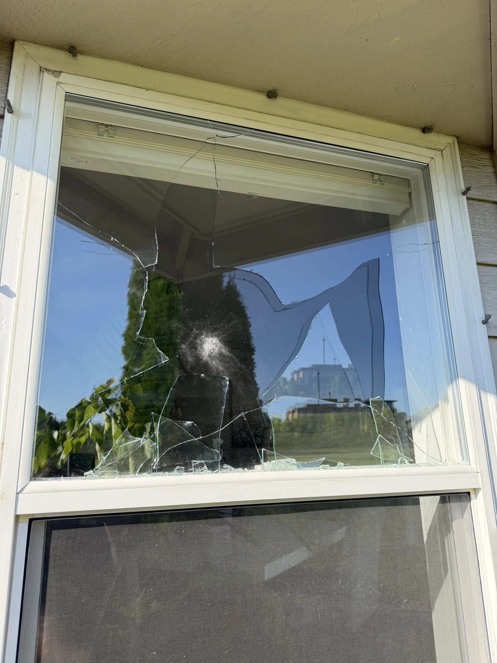 Double-hung window with cracked glass before repair