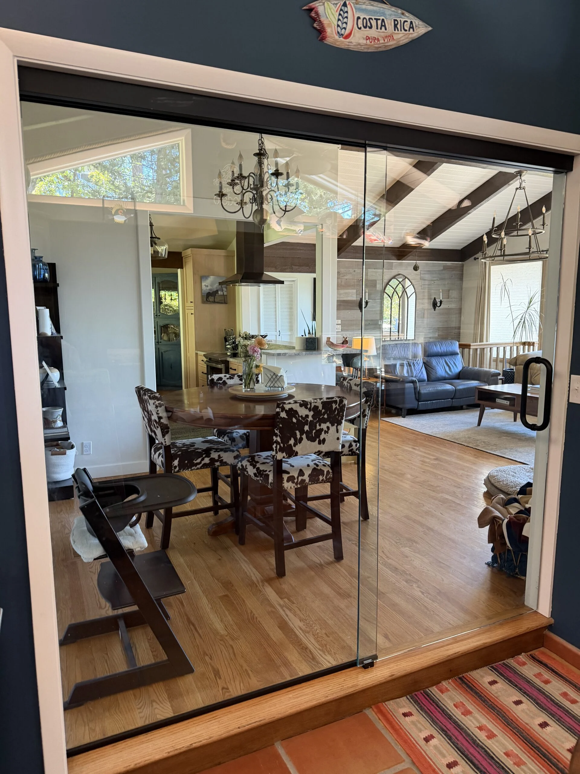 Frameless glass doors opening into a dining and living room