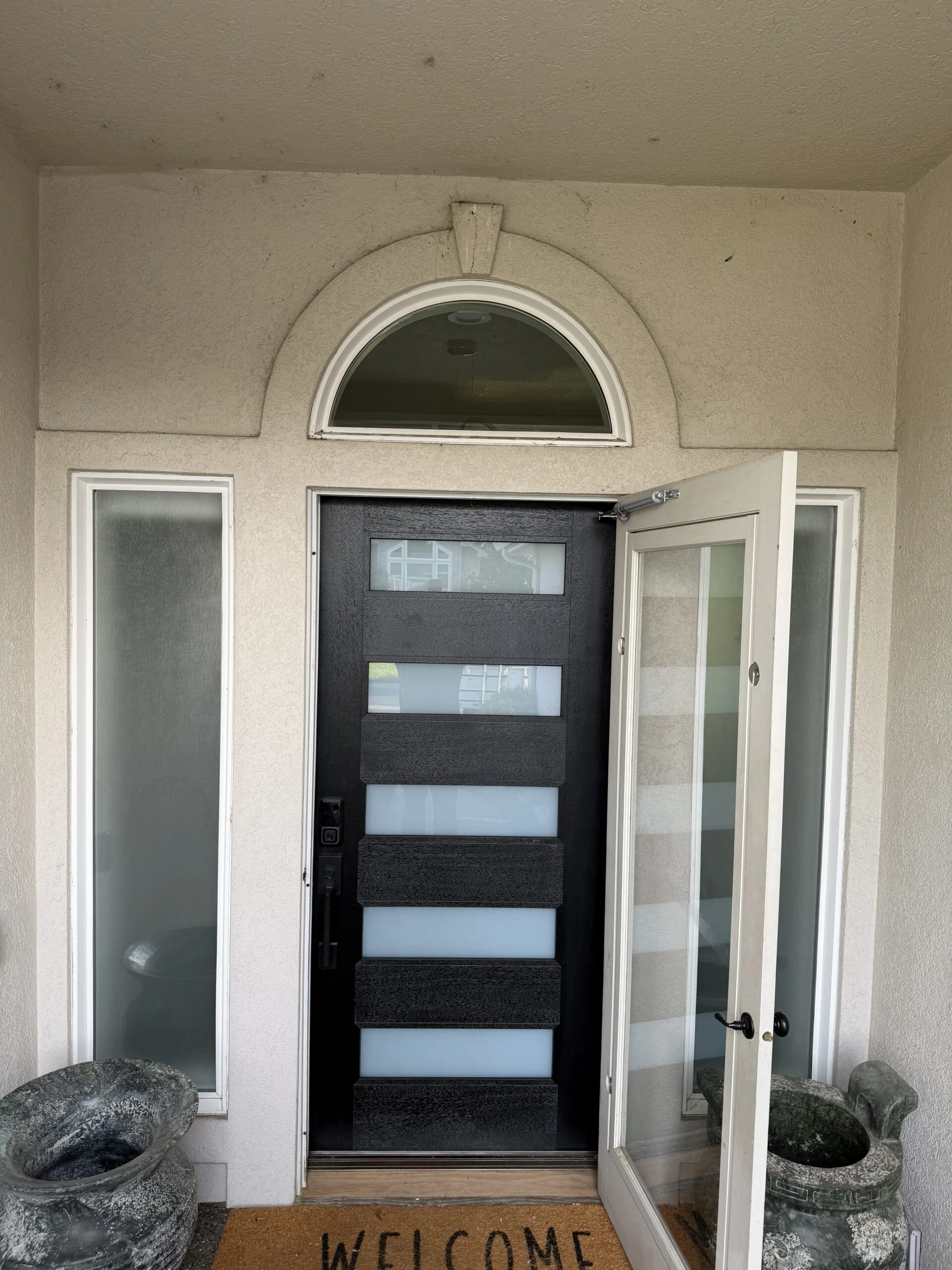 Front entry with frosted glass sidelights and arched transom