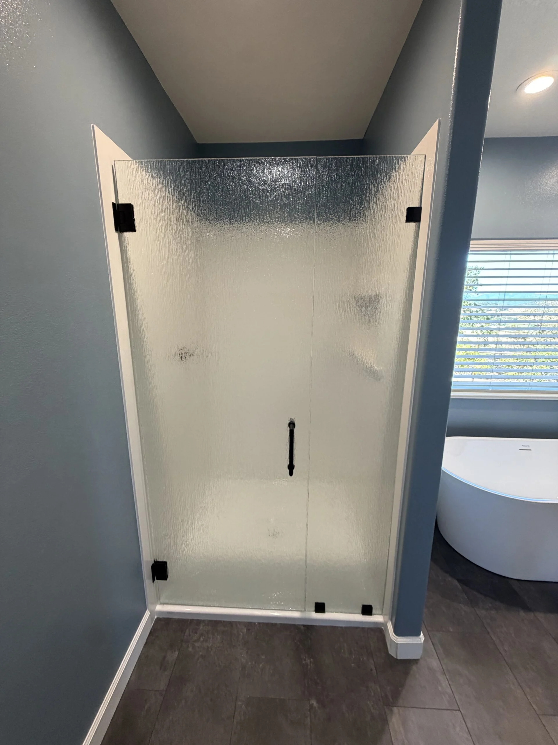 Frosted glass shower door with matte black hinges and handle